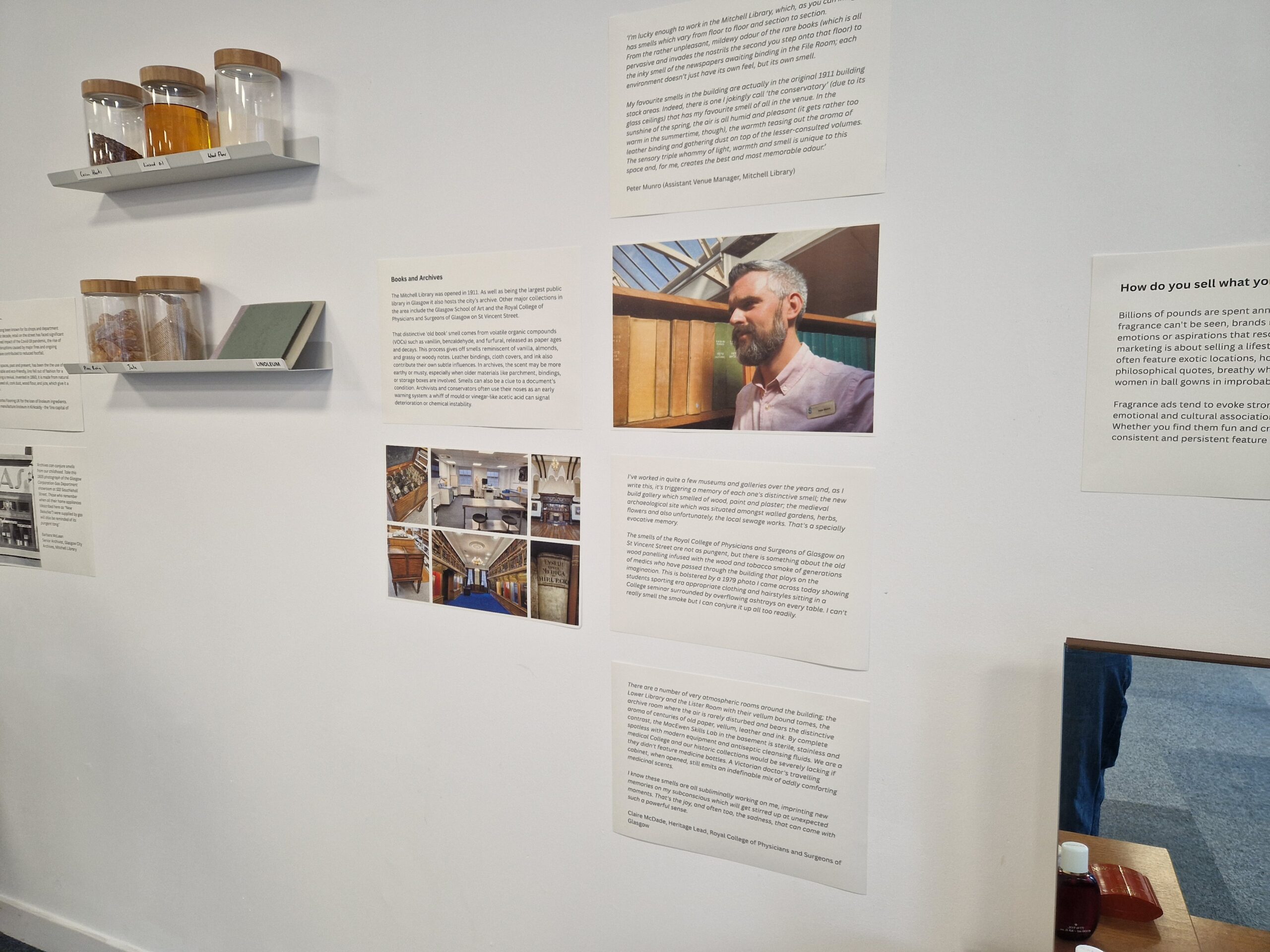 A white wall with posters showing text and a photo of a man.