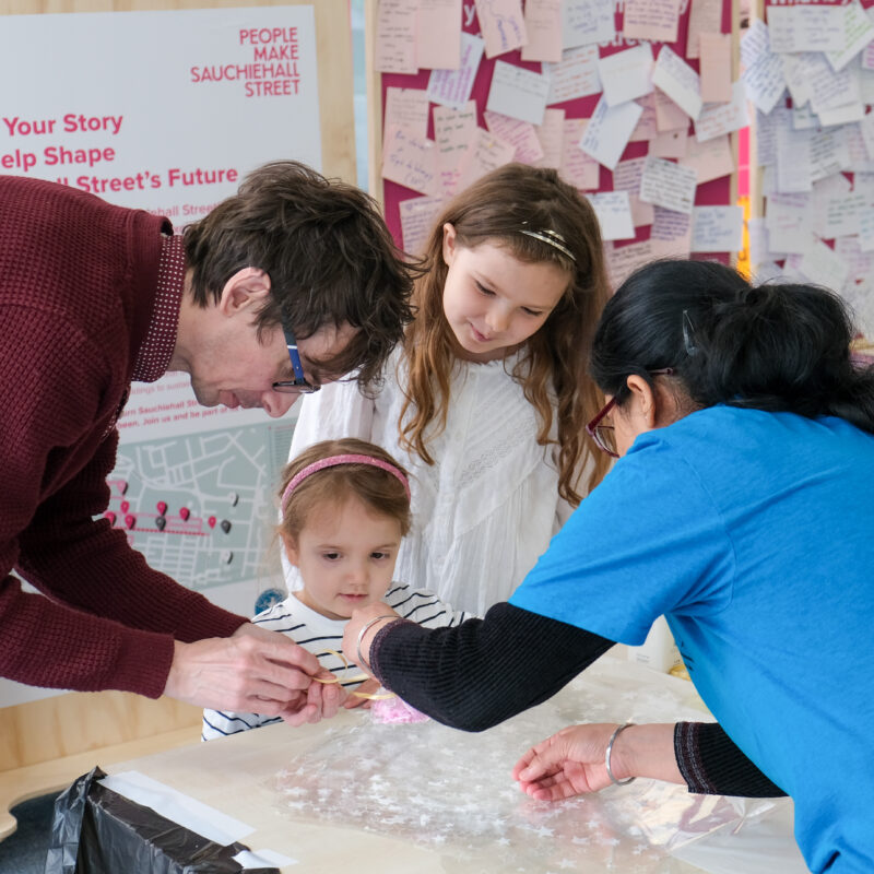 Three adults and a child gathered around a table