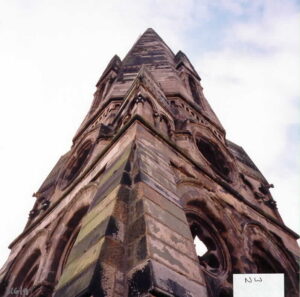 Looking up at a large stone built steeple.