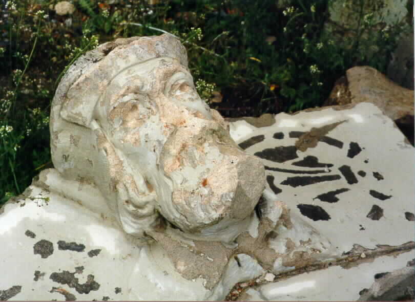 A carved stone face of a man with a beard.