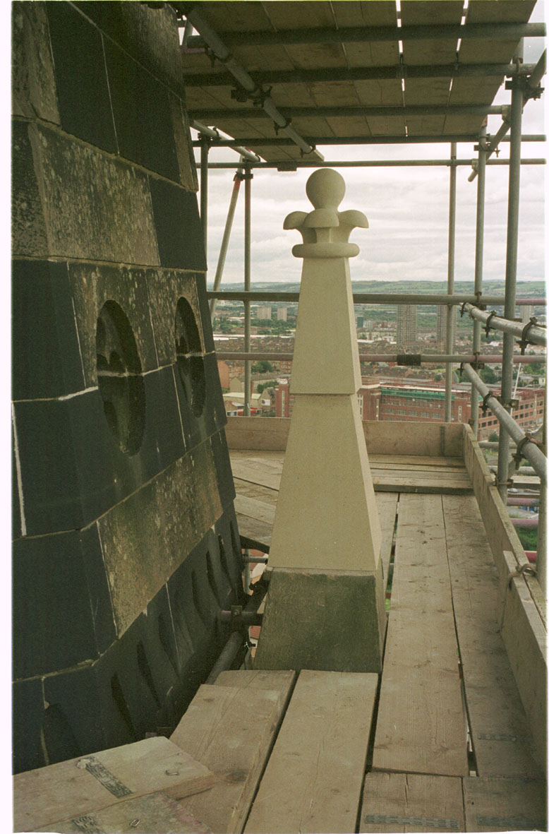 View from a scaffold of a large, pointed, carved stone.